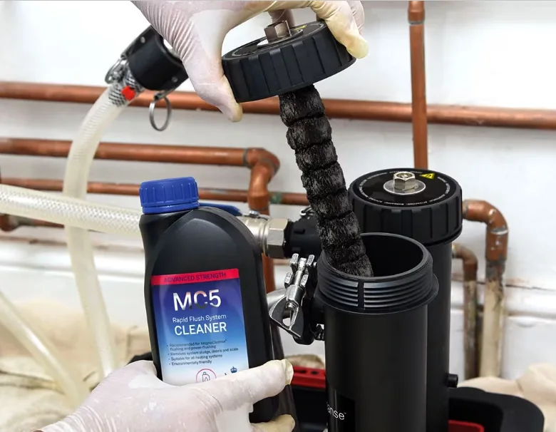 MagnaCleanse filter being emptied of magnetic sludge during a system flush