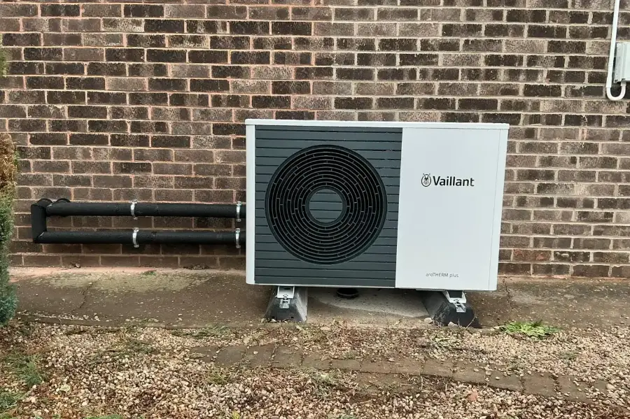 Vaillant air source heat pump mounted against a brick house wall
